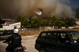 Un avion largue de l’eau pour éteindre le feu à Acharnes, au nord d’Athènes, le 23 août 2023.