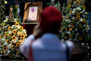 Un fidèle photographie le portrait du pape installé dans la cathédrale Saint-Sébastien de Rio de Janeiro, lundi 21 avril, après l’annonce de la mort de François.