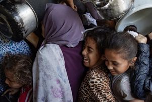 Des centaines de Palestiniens déplacés se rassemblent devant la cuisine caritative Sokar dans la ville de Gaza pour recevoir des rations alimentaires limitées, le 21 mai 2025. 