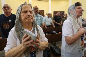 Des Arméniens lors d’une messe à l’église de la Sainte-Croix à Erbil, la capitale de la région autonome kurde du nord de l’Irak, le 25 avril 2025, pour marquer le 110e anniversaire des massacres de masse des Arméniens pendant la Première Guerre mondiale sous l’Empire ottoman en 1915.