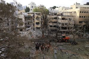 Les services de secours israéliens interviennent lundi 16 juin dans un immeuble touché par un tir de missile iranien à Tel Aviv.  